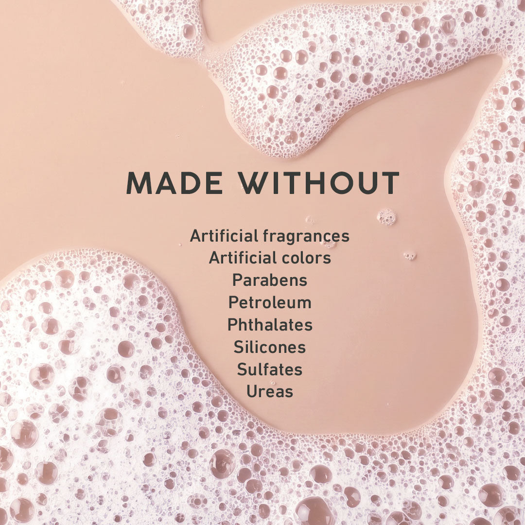 A square graphic with a peach-beige liquid background and white foam around the edges. Centered text reads “MADE WITHOUT” followed by a list of excluded ingredients: Artificial fragrances, Artificial colors, Parabens, Petroleum, Phthalates, Silicones, Sulfates, Ureas.