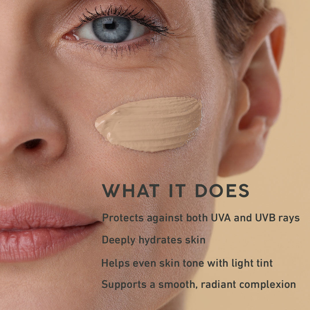 Close-up of a woman's face with a cosmetic product swatch on her cheek, against a beige background.