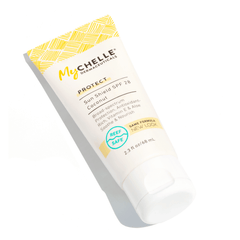 A tube of MyChelle Sun Shield SPF 28 Coconut sunscreen on a white background