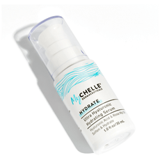 A bottle of MyChelle Ultra Hyaluronic Hydrating Serum with a white and blue label, set against a white background. Label states product soften and hydrate.